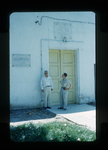 Two men outside a building by Haven L. Miller