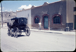 Horse and buggy with church and preacher's house by Haven L. Miller