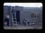 group in front of a building under construction by Haven L. Miller