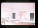 Man inside church building standing behind a pulpit, likely Iglesia de Cristo in Mexico by Haven L. Miller