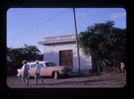 two men walking in front of a building, perhaps an Iglesia de Cristo by Haven L. Miller